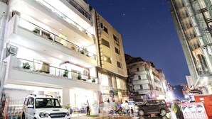 Un edificio a più piani con balconi, un autolavaggio e un ristorante.