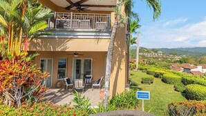 A two-story building with a balcony, a patio with chairs, and a sign indicating a private residence.