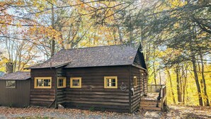 A rustic log cabin with a chimney, a small porch, and a number '10' sign.