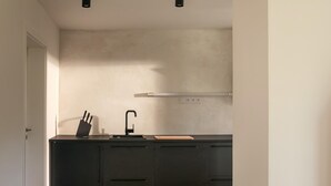 Eine moderne Küche mit schwarzer Arbeitsplatte, Spüle und Messerblock.