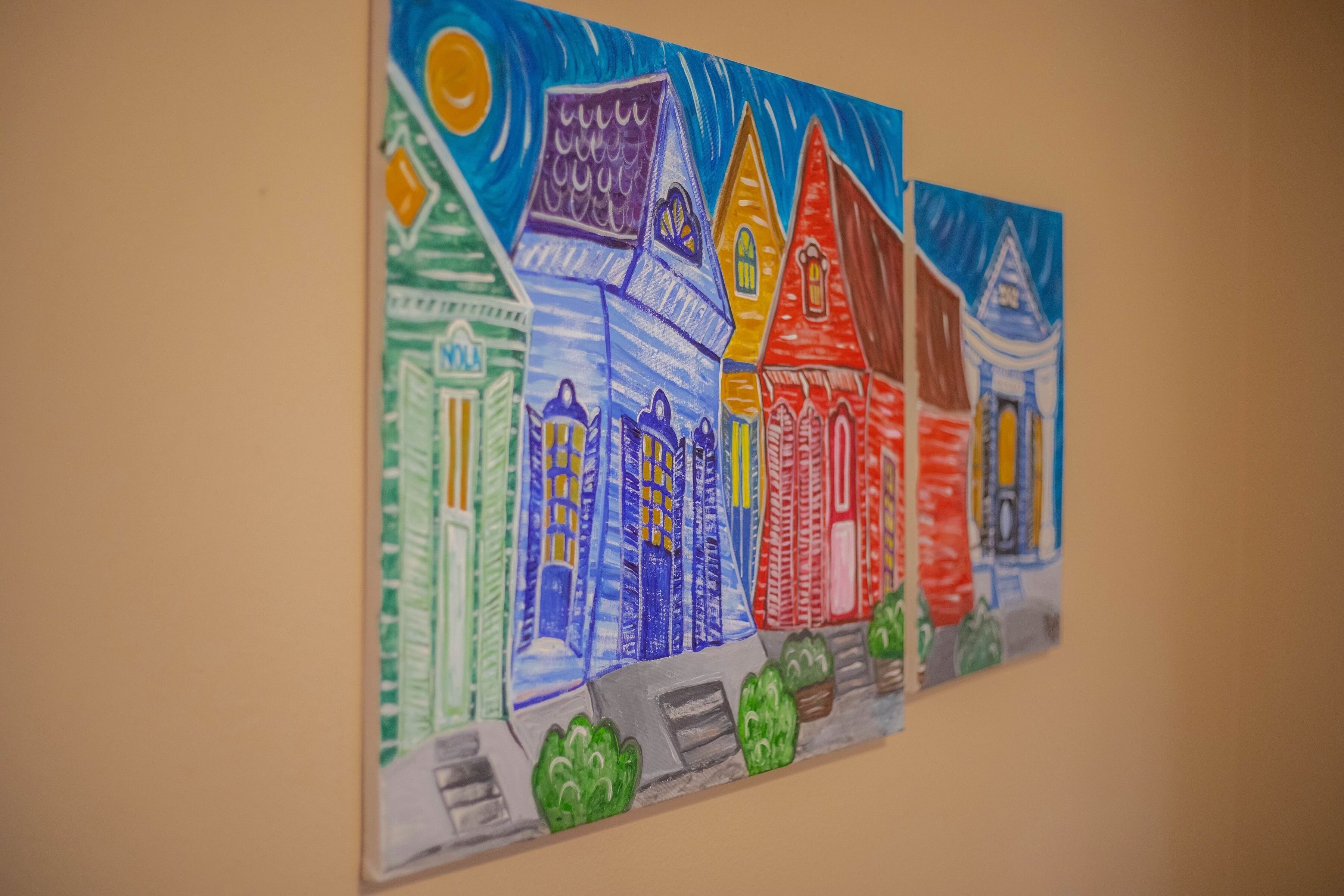 Une fresque colorée représentant des maisons, peinte sur un mur.