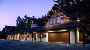 Een modern gebouw met meerdere garagedeuren, grote ramen en een grindpad.
