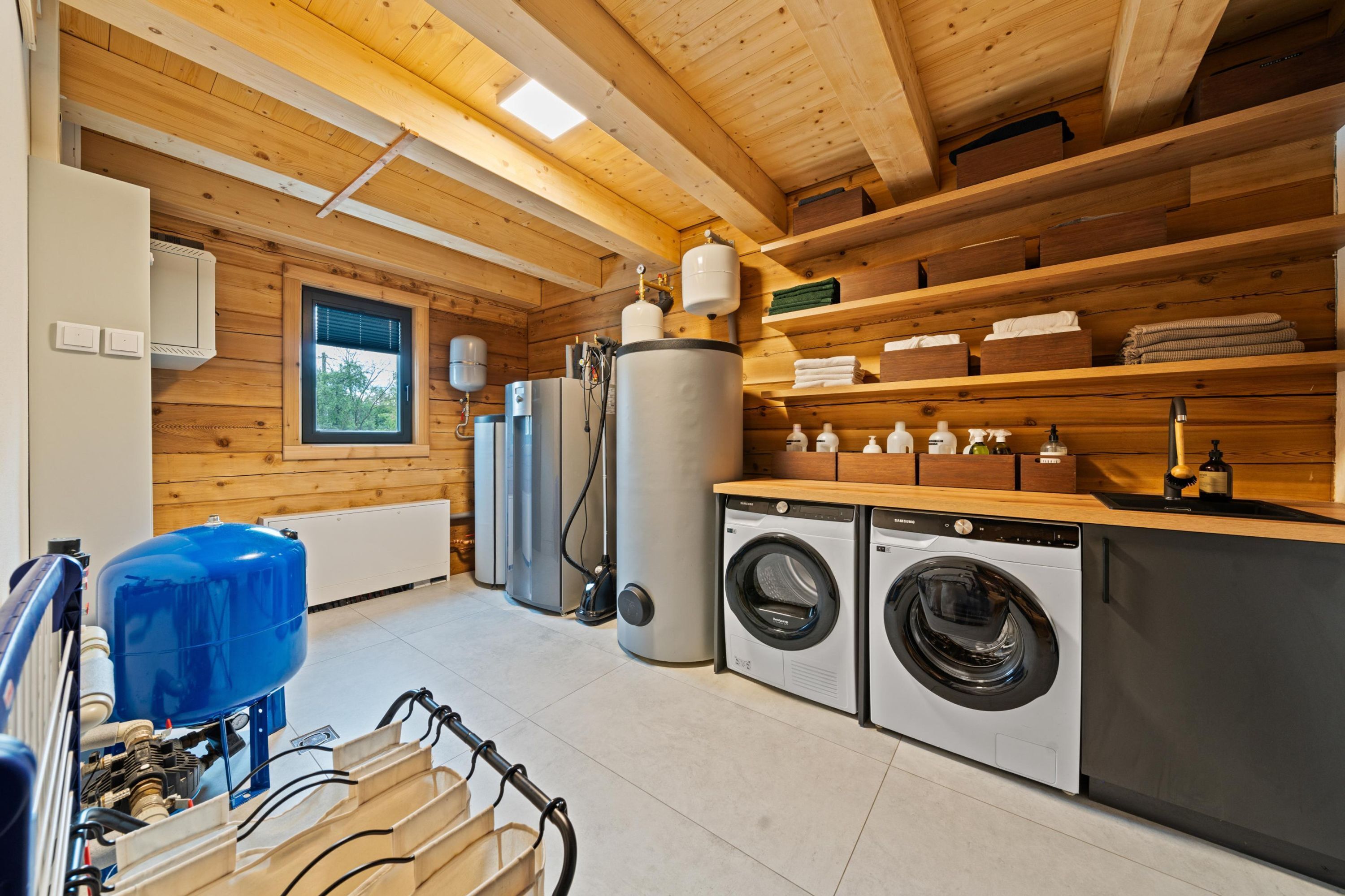 A laundry room with a washing machine, dryer, and stacked laundry baskets.