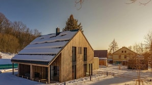 A wooden cabin with a sloped roof and large windows, surrounded by snow. - Cerny Dul Kcml115 in Cern Dul (Cerny Dul)