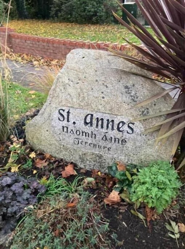 St. Anne's garden marker sits amidst lush greenery.