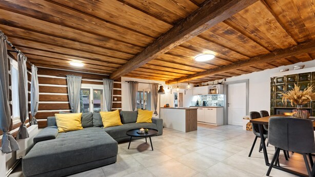 A modern living room with a grey sofa, yellow cushions, a round coffee table, and a dining area with a wooden table and chairs. - Dolni Branna Kdb026 in Doln Brann (Dolni Branna)