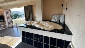 Una habitación moderna con chimenea, un ventanal grande y vistas al exterior.
