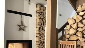 Un interior acogedor con chimenea, una escalera de madera y una decoración de estrella en la pared.