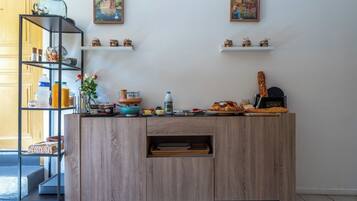 Een keuken met een houten aanrecht, planken met keukengerei en decoratieve voorwerpen.