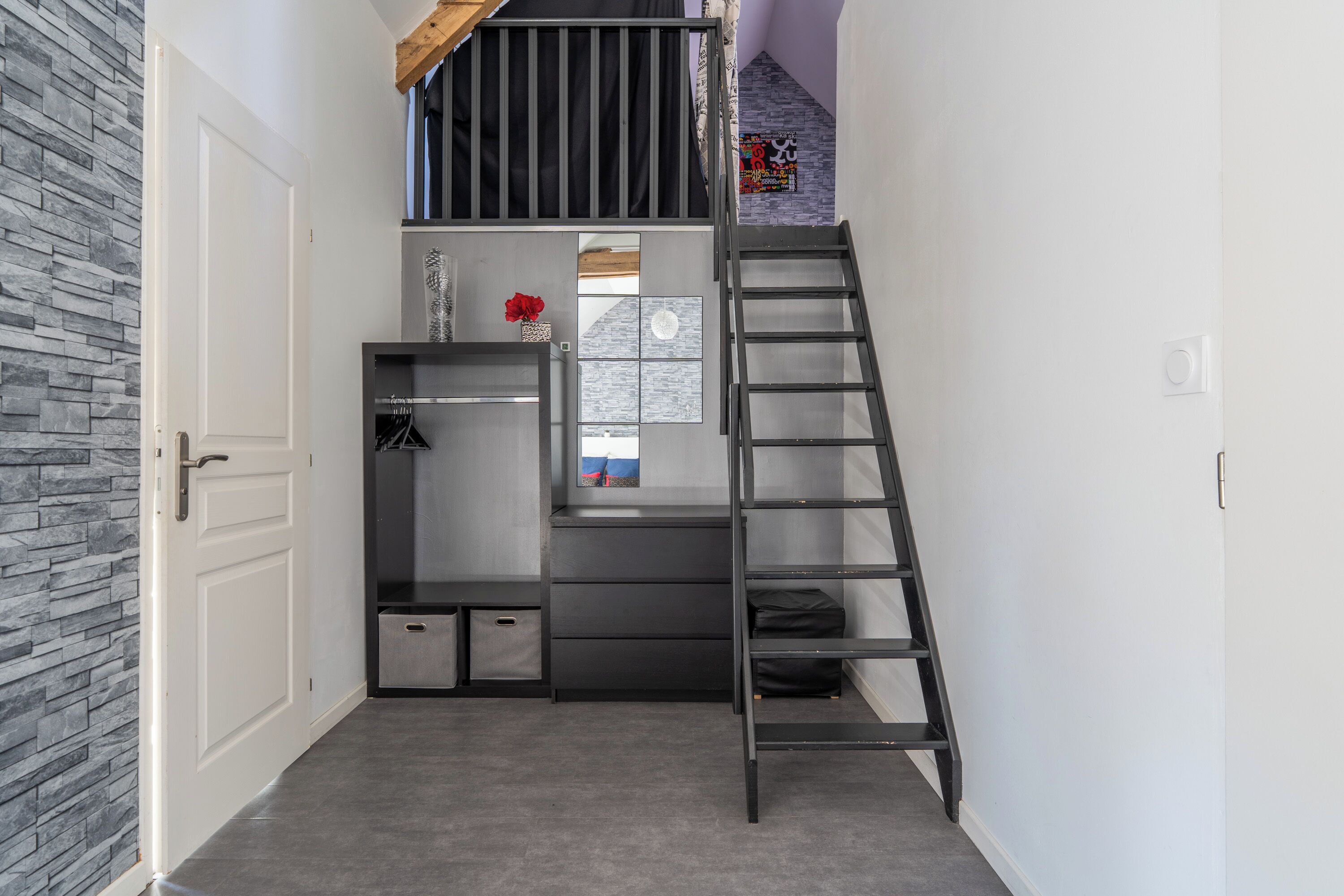 Una habitación compacta con escritorio integrado, una escalera y ventana con vistas.
