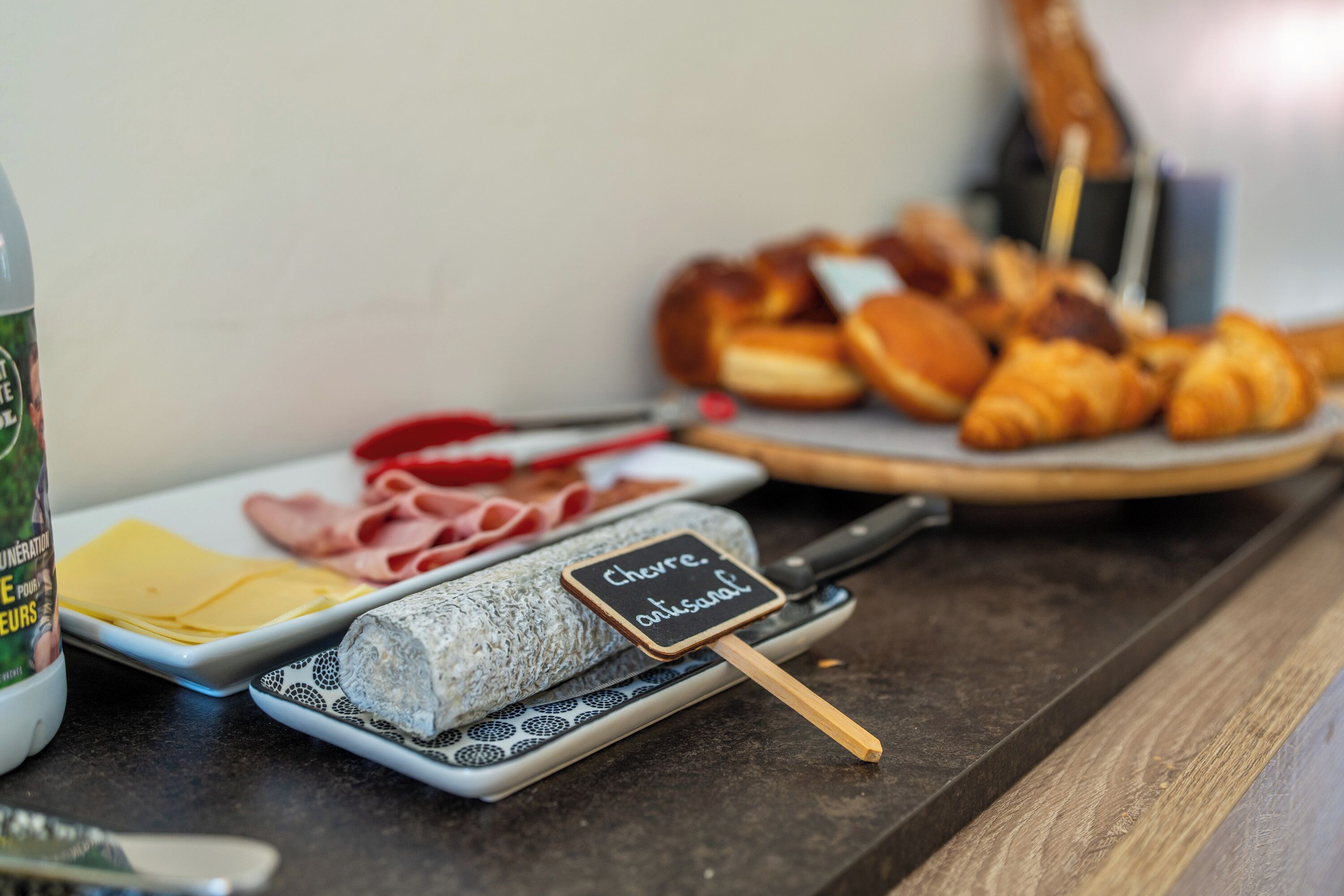 A variety of food items including cheese, cured meats, and pastries on a counter.