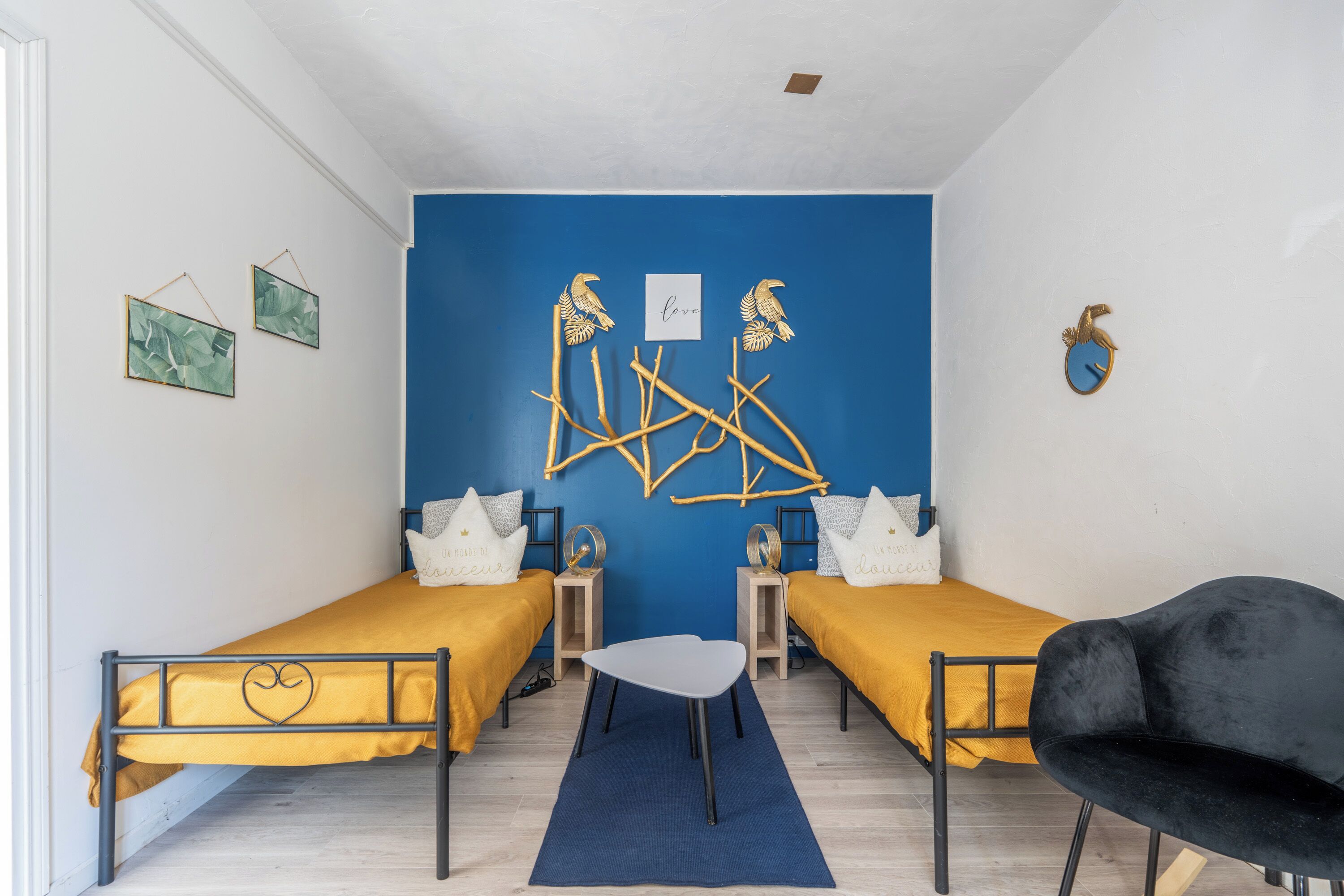 A room with two beds, a small table, and a chair.