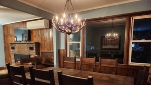 A dining area with a long wooden table, six chairs, and a chandelier. - West Mountain Ski & Adventure Home w/ Hot Tub
 (Queensbury)