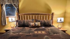 A bed with a wooden headboard, two nightstands with lamps, and a window with a view of trees. - West Mountain Ski & Adventure Home w/ Hot Tub
 (Queensbury)