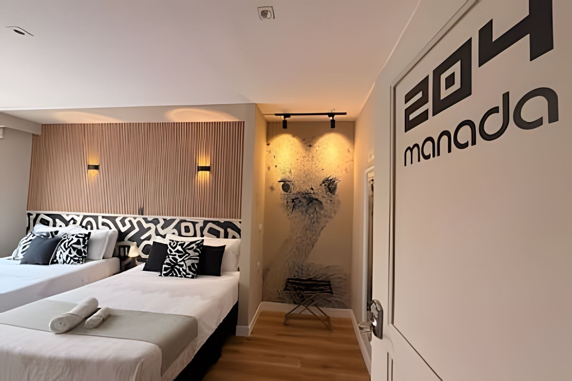 A modern hotel room with two beds, a wooden panel wall, and a unique wall art piece.