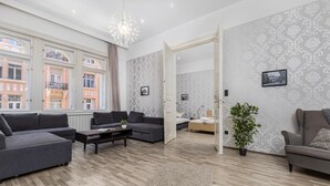 Een moderne woonkamer met een zithoek, een salontafel en een potplant.