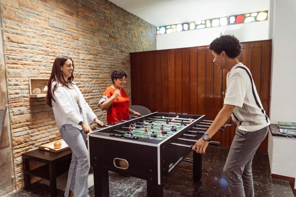 Una habitación con mesa de fútbol, pared de ladrillo y paneles de madera.
