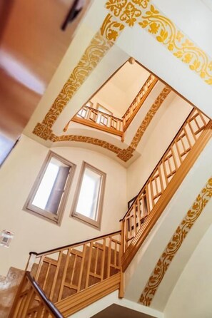 A multi-level interior with a wooden staircase, decorative wall patterns, and windows. - Leevin Stay Barcelona (Barcelona)