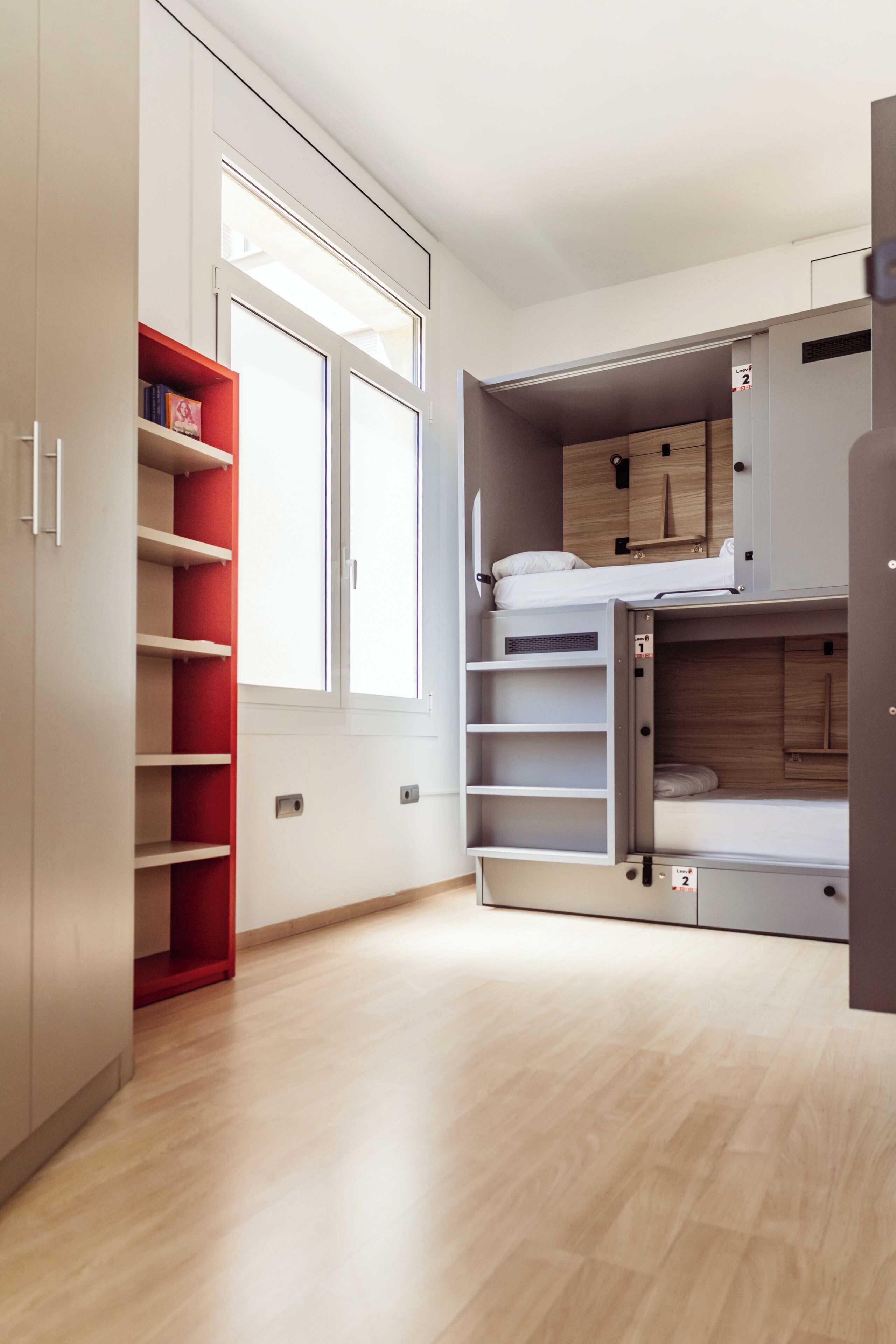 Una camera moderna con spazio contenitori integrato, una finestra e un letto a castello.