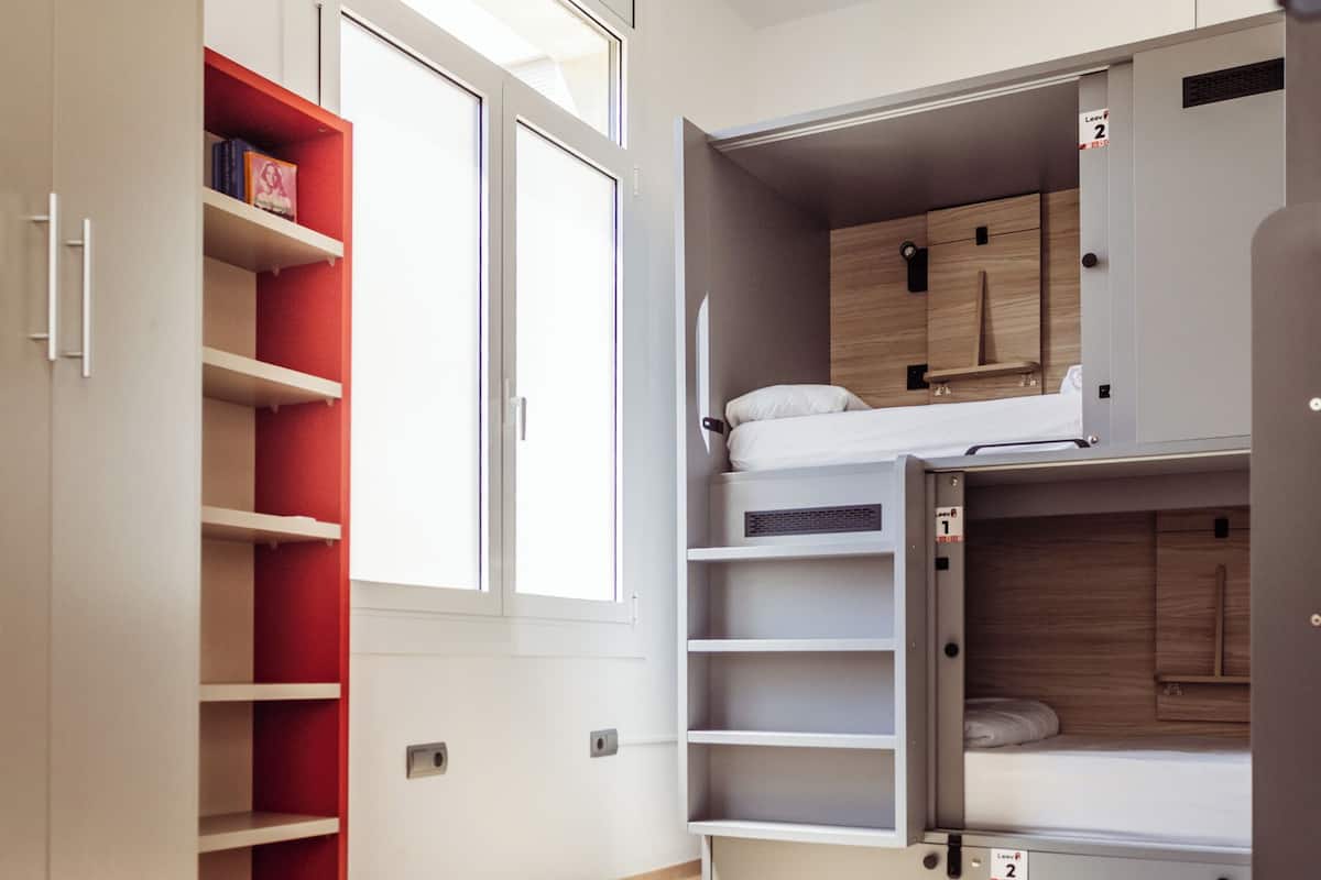Una habitación moderna con almacenamiento integrado, una ventana y una cama litera.