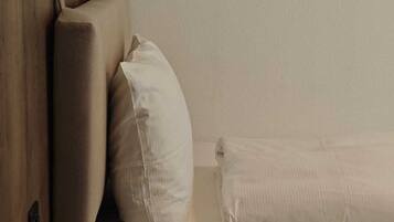 A bed with a wooden headboard and two pillows.