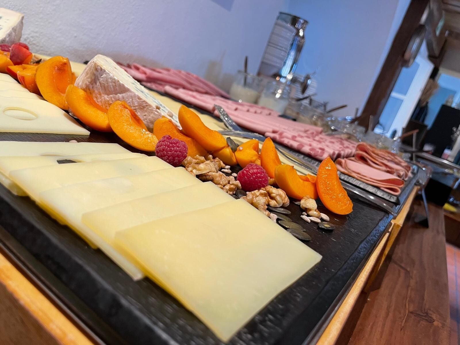 Un buffet proposant une variété de fromages, de fruits et de noix.