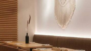A modern dining area with wooden tables and brown upholstered chairs.