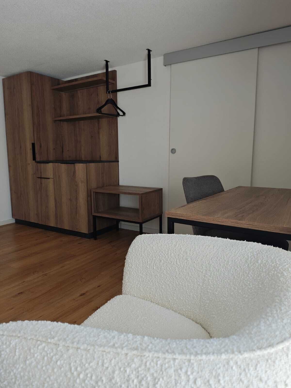 Une pièce moderne comprenant un meuble en bois, une petite table, un canapé et une table à manger.
