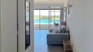 A hallway leading to a balcony with a view of a pool.
