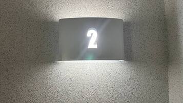 A wall-mounted light fixture with the number '2' illuminated.