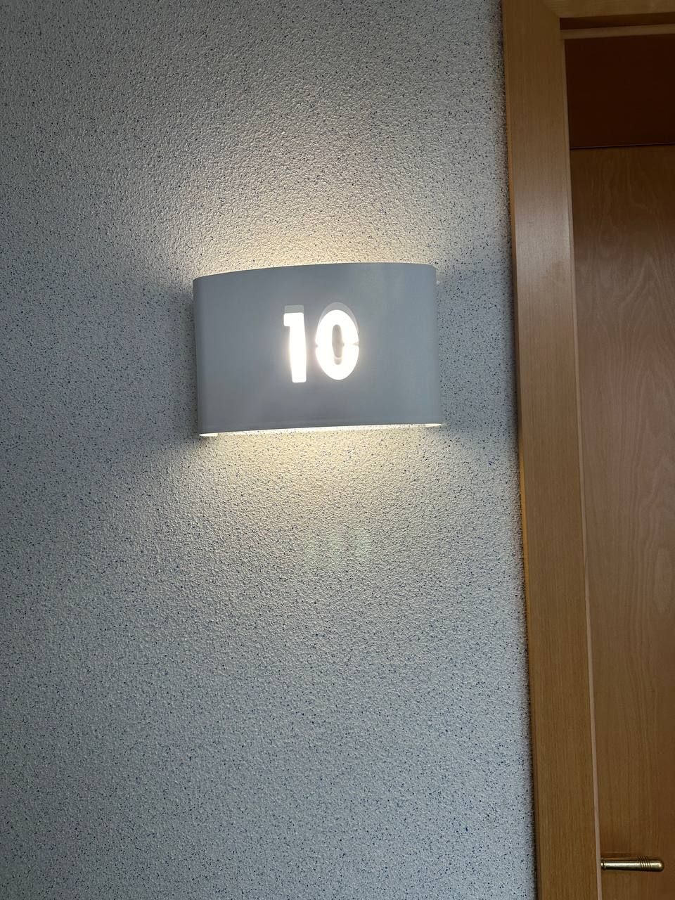 A wall-mounted sign with the number '10' illuminated.