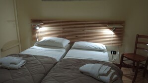 A hotel room with two single beds, a wooden headboard, a chair, and a bedside table with a lamp. - Hotel Eliseo Napoli (Naples)