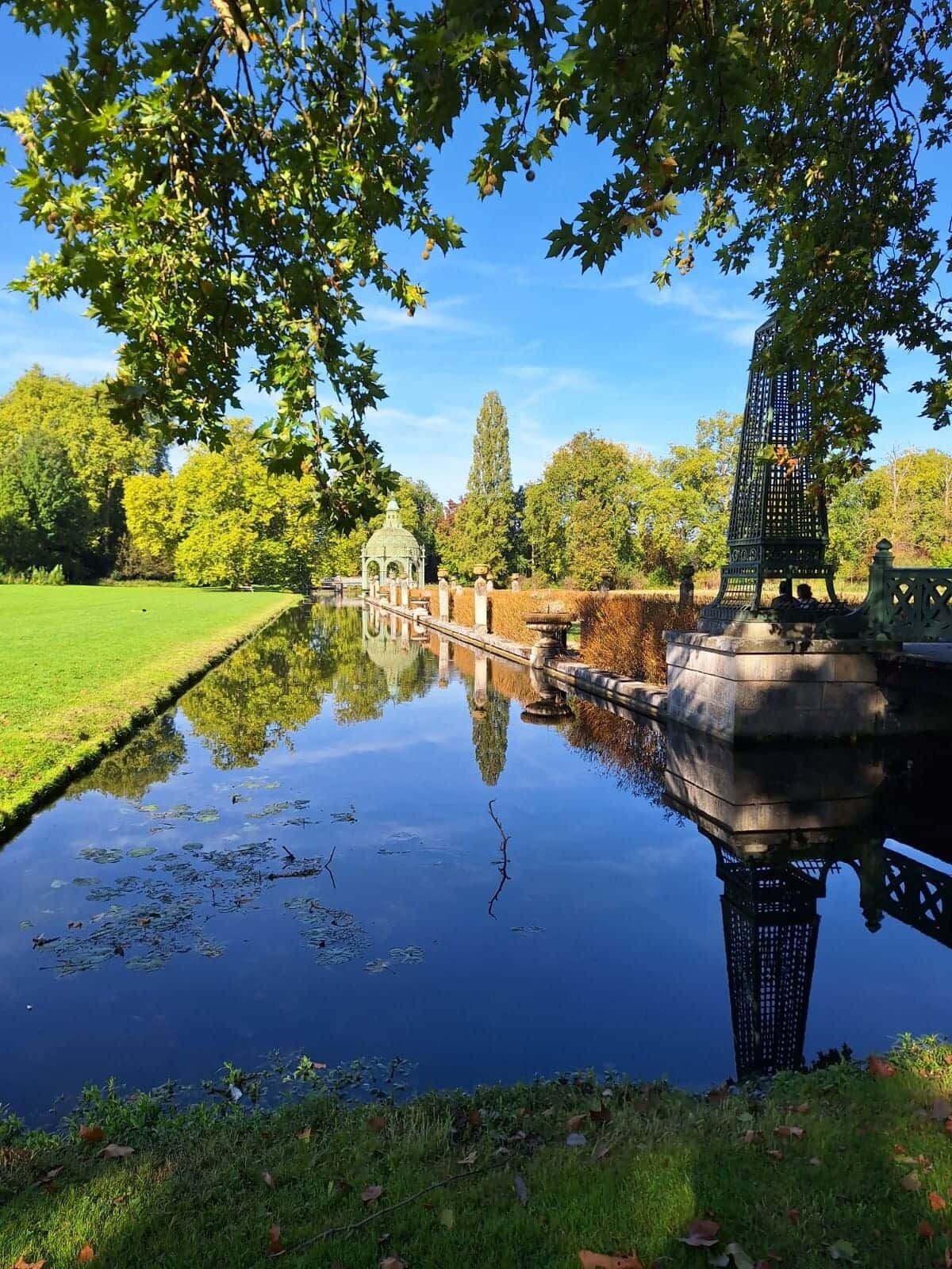 Ein ruhiger Garten mit Teich, Laube und Springbrunnen.