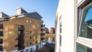 Un edificio residencial de varios pisos con fachada de ladrillo, varios balcones y vistas a un río.