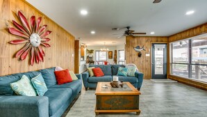 A living room with two blue sofas, a wooden coffee table, and a decorative wall piece. - Private Dock, Lanai: Bayou Retreat in Barataria! (Barataria)