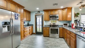 A modern kitchen with wooden cabinets, stainless steel appliances, and a granite countertop. - Private Dock, Lanai: Bayou Retreat in Barataria! (Barataria)