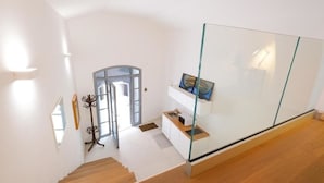 A modern interior with a staircase leading to a glass-enclosed balcony. - Old Stone House. Spacious Loft in the heart of the old town a stone's throw from the sea (Bari)