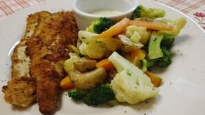 A plate with a breaded cutlet, mixed vegetables, and a small bowl of sauce. - SHI Hotel (Hukuntsi)