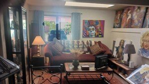 A living room with a sofa, a coffee table, a lamp, and a painting on the wall. - Randy's Roost -- Private unit within an artists home/studio and gallery. (Santa Fe)