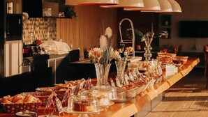 Montaje de bufé con diversos alimentos y elementos decorativos.