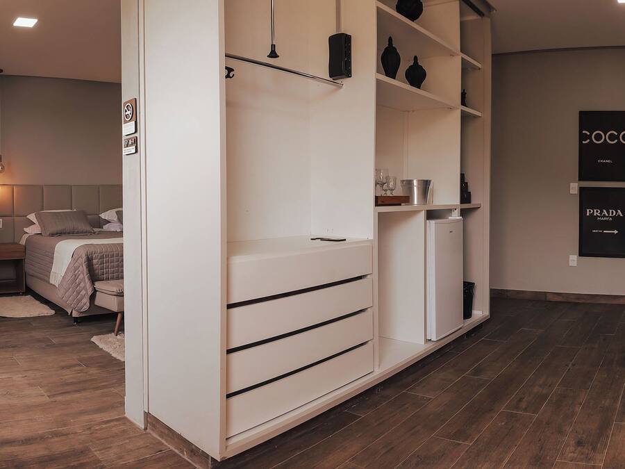 A modern bedroom with a bed, bedside table, and a wardrobe with shelves.