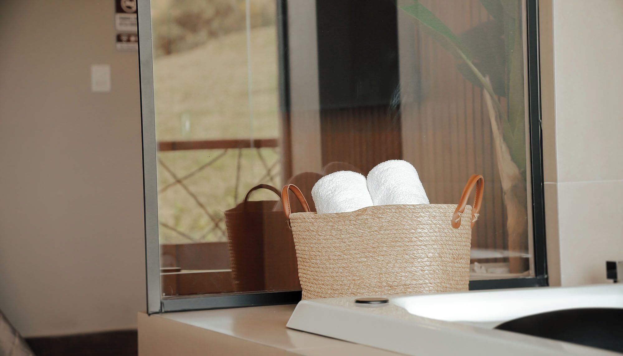 A woven basket with towels on a windowsill.