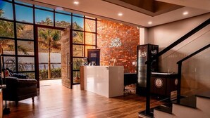 Una zona de recepción moderna con pared de ladrillo, mostrador de recepción y una escalera.