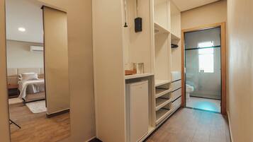 A hallway with a bed, a wardrobe, and a bathroom.