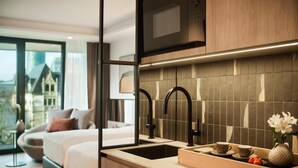 Habitación de hotel moderna con una cama grande, lavamanos integrado y vistas a un paisaje urbano.