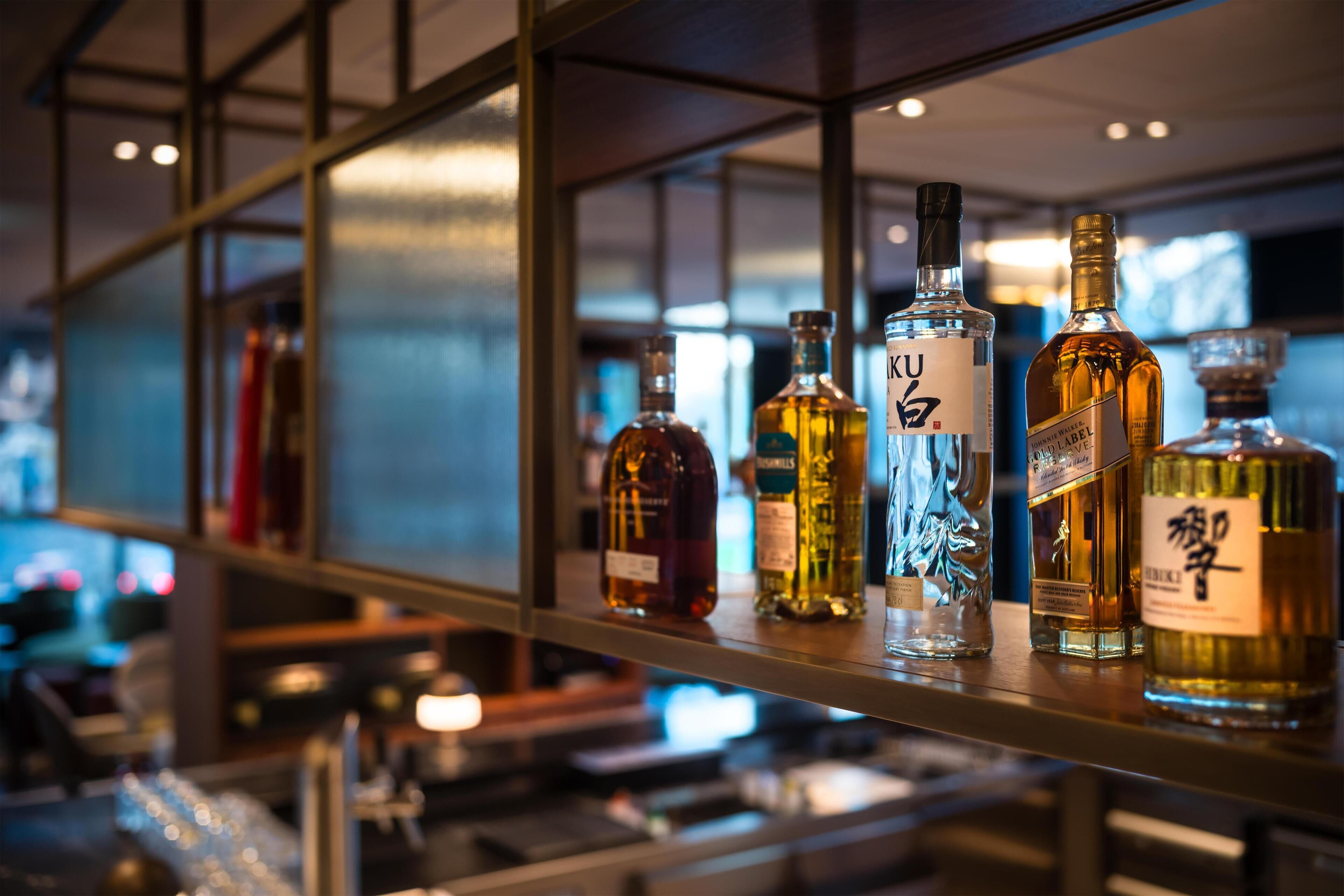 Eine Bar mit verschiedenen Spirituosenflaschen in Regalen.