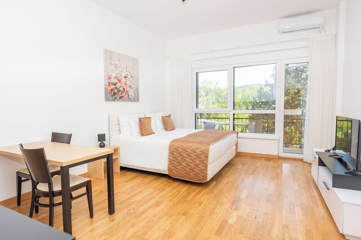 Une chambre d’hôtel moderne équipée d’un lit, d’un bureau et d’une télévision.
