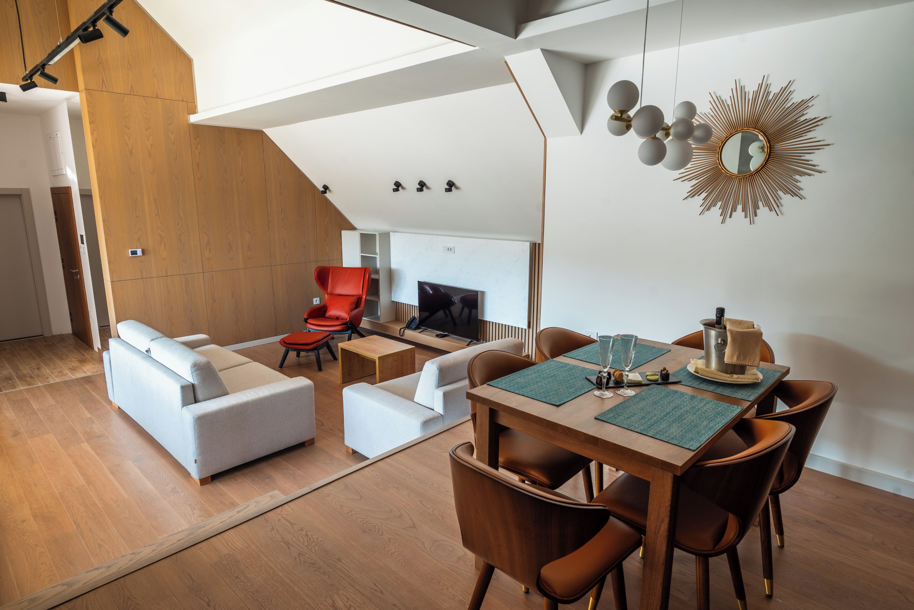 A modern living room with a sofa set, a dining table with chairs, and a fireplace.