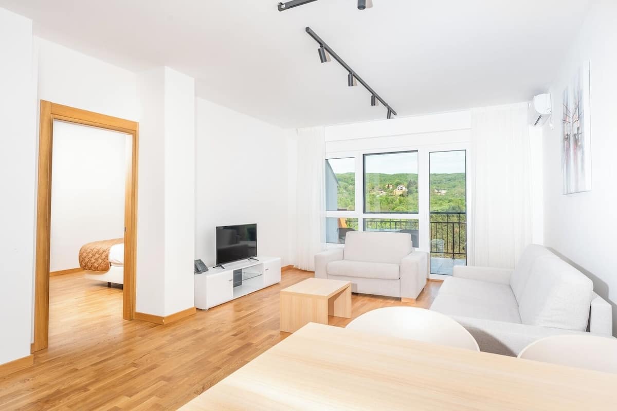 Un salon moderne avec un téléviseur, un canapé et une table à manger.
