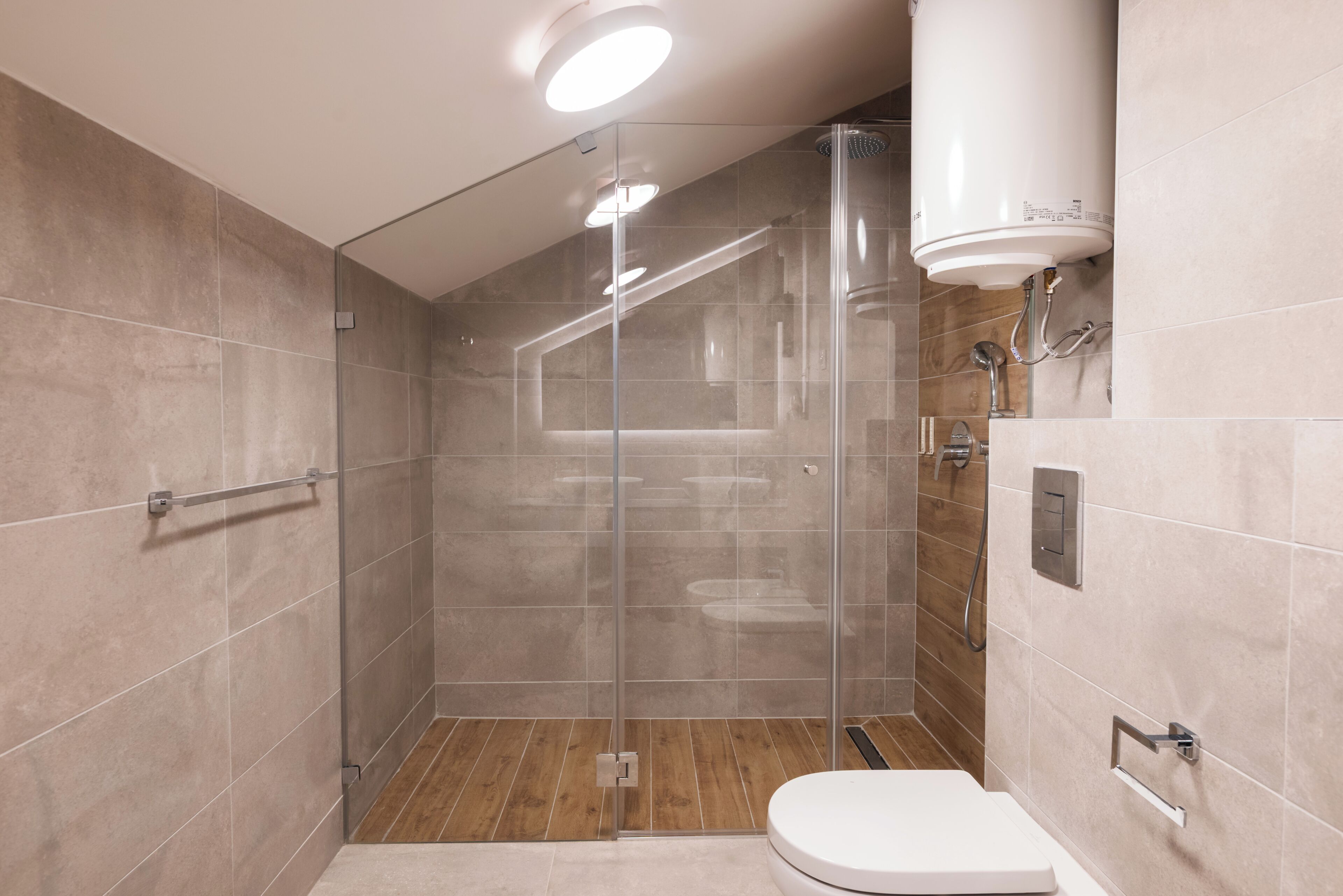 Un baño moderno con ducha de vidrio, inodoro y lavamanos.